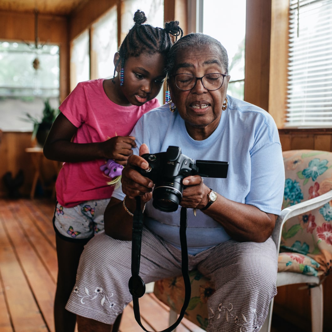 A young girl and her grandmother looking at photos on a digital camera