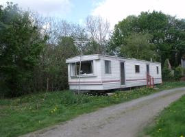 caravan nestled away amongst trees on edge of farm yard, hotel in Bala