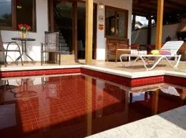 Refúgio com Piscina Vermelha - 3 Suítes, Churrasqueira e Praia na Esquina!