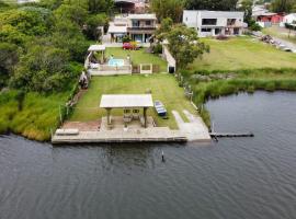 Casa na beira da lagoa com piscina e rampa para embarcações, casa de férias em Tramandaí