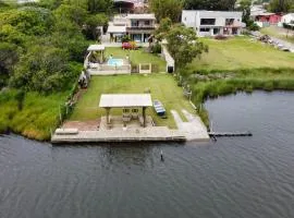 Casa na beira da lagoa com piscina e rampa para embarcações