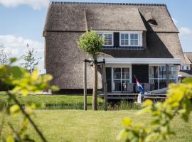 Thatched villa with lounge set, right at the water, hotel en Delfstrahuizen