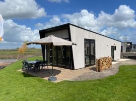 Tiny vakantiehuis aan het water met eigen steiger en airco, hotel in Kampen