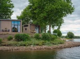 Cozy tiny house on the water, located in a holiday park in the Betuwe