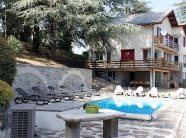 Chalet 14 pers avec vue panoramique et piscine chauffée โรงแรมที่มีที่จอดรถในGénolhac