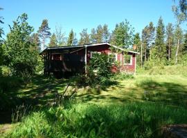 Typisches Holzhaus mit überdachter Terrasse auf weitläufigen Grundstück in einem Waldgebiet am See, hotel in Hallaryd