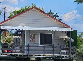 House on the river, boat in Kolonija
