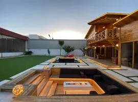 كوخ بتصميم مودرن وجاكوزي عالهواء الطلق بمساحات واسعه ومسبح اضافي