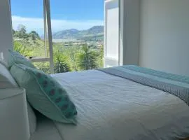 Sunny hillside central Nelson hideaway with city to sea views