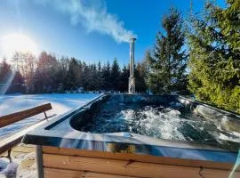 Domek z kominkiem nad jeziorem z jacuzzi ogrodowym
