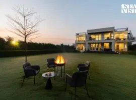 StayVista at Olive Farms with Lawn, Pool, Bonfire & Hill Views