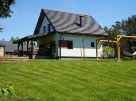 Domek z kominkiem nad jeziorem z jacuzzi ogrodowym