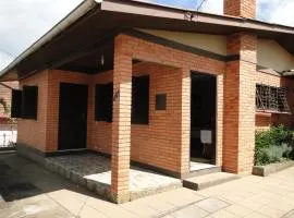 Casa Completa, 300m da Praça, Wi-Fi, 130m quadrados, 4 Camas de Casal, 4 Quartos, Até 11 Pessoas, Quintal com Vasta Área Verde, Varanda nos Fundos, Garagem Coberta 1 Carro, Estacionamento Interno 2 Carros, Churrasqueira, Fogão a Lenha