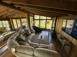 5 Star Country Retreat, huge Log Cabin over small river, with private hot tub & log burner, WiFi, 65 inch smart TV relax read at Weston Newark, Nottinghamshire