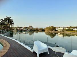 Spacious waterfront home with pontoon, pool, BBQ, hotel em Kawana Waters