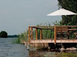 Lakefront house with beach, jetty, and rowing boat