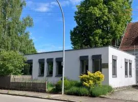 Kubisches freistehendes Ferienhaus mit Blick auf einen Weiher