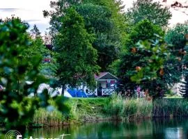 Forteca, rustykalne drewniane domki nad brzegiem stawu, łazienki współdzielone