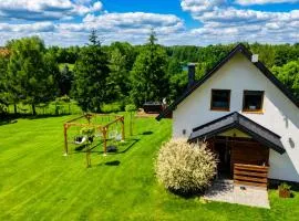 Domek z kominkiem nad jeziorem z jacuzzi ogrodowym