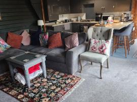 Chalet close to Heathrow T5, Windsor Castle, Legoland, Thorpe Park, with off road parking, free Wifi, private garden, spacious & fully equipped, cozy wood burner & comfy sofa, ideal for exploring London with trains to Waterloo, a beautiful unique retreat, Hotel in Colnbrook