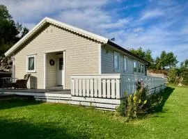 Seaside family cabin with fjord view, outdoor lounge & boat on a private dock