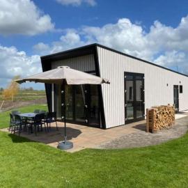 Tiny vakantiehuis aan het water met eigen steiger en airco, hotel in Kampen