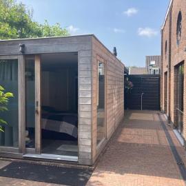 Tuinhuis aan het water met woonkamer, hotel a Voorburg