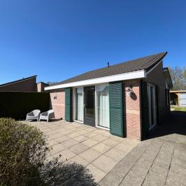 Knusse bungalow met omheinde tuin met veranda, hotel din Tzummarum