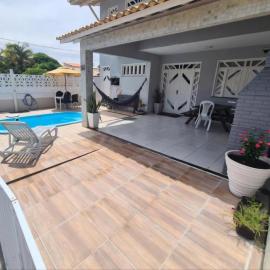 Casa cinza em frente à praia em condominio