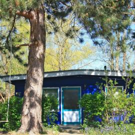 Blauer Bungalow am See mit Boot