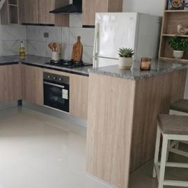 A one-bedroom apartment with a living room, kitchen, and balcony
