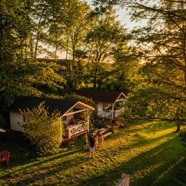 Forteca, rustykalne drewniane domki nad brzegiem stawu, łazienki współdzielone