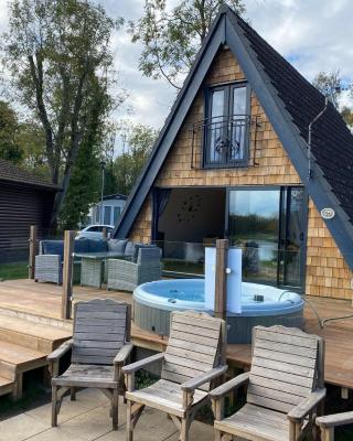 Widgeon Bespoke Cabin is lakeside with Private fishing peg, hot tub situated at Tattershall Lakes Country Park