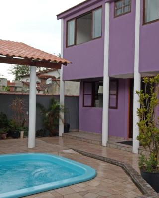 Casa roxa com piscina em condomínio