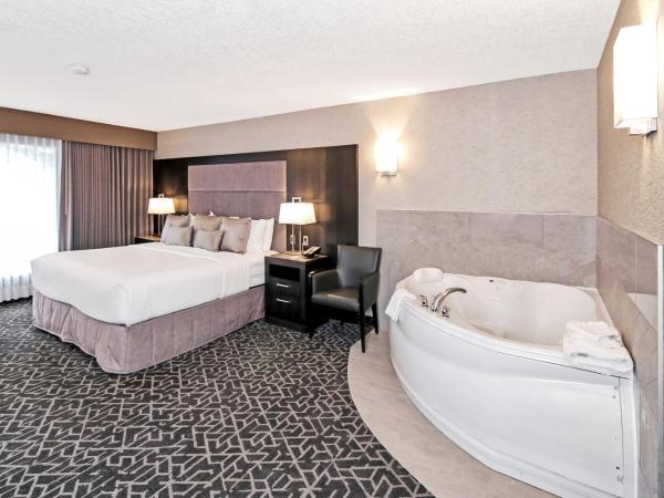 Best Western Plus Siding 29 Lodge : photo 9 de la chambre suite lit king-size avec baignoire spa et canapé-lit