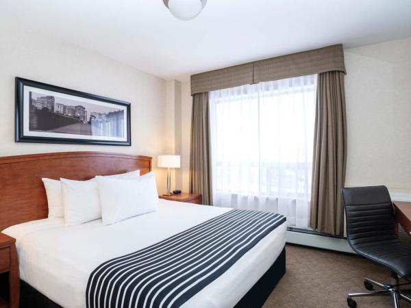 Sandman Hotel & Suites Calgary West : photo 1 de la chambre suite standard avec 1 lit king-size, canapé-lit, kitchenette
