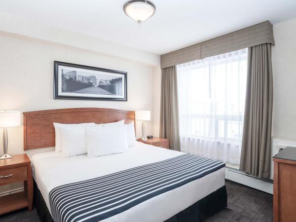 Sandman Hotel & Suites Calgary West : photo 1 de la chambre grande suite avec 1 lit king-size, canapé-lit et kitchenette