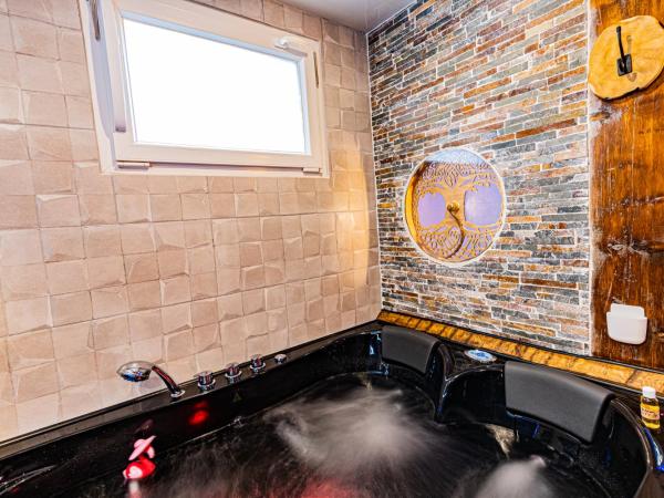 Le Néflier Dijon - appart balnéo - SPA romantique pour 2 : photo 1 de la chambre chambre lit queen-size avec baignoire spa