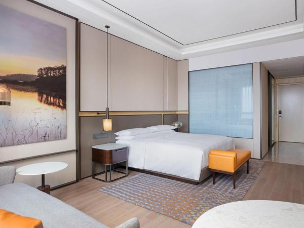 Sheraton Shanghai Fengxian : photo 2 de la chambre chambre lit king-size avec accès au salon club - vue sur ville.