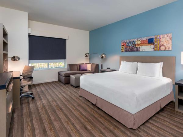 Hyatt House Orlando Airport : photo 1 de la chambre chambre lit king-size avec douche accessible en fauteuil roulant den - accessible aux personnes à mobilité réduite