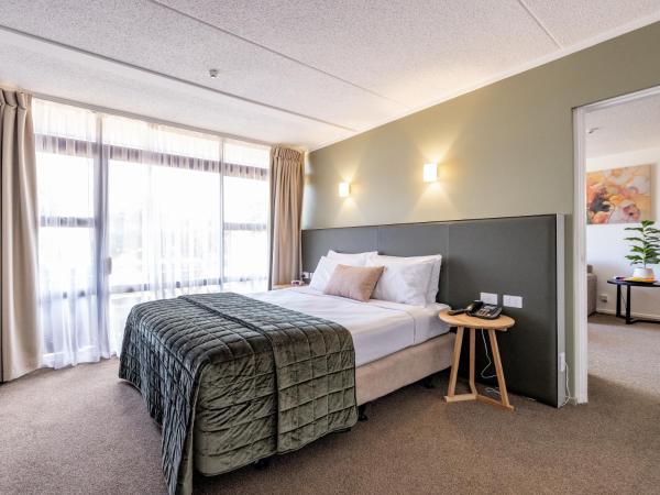 Auckland Rose Park Hotel : photo 1 de la chambre hébergement lit king-size supérieur avec salon et balcon