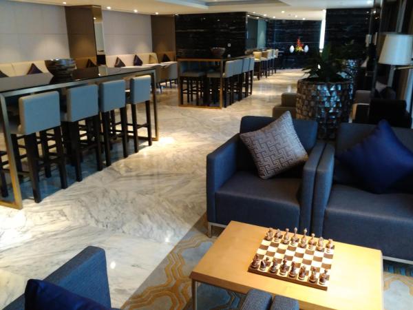 Grand Millennium Muscat : photo 2 de la chambre chambre club avec lit king-size et accès au salon exécutif