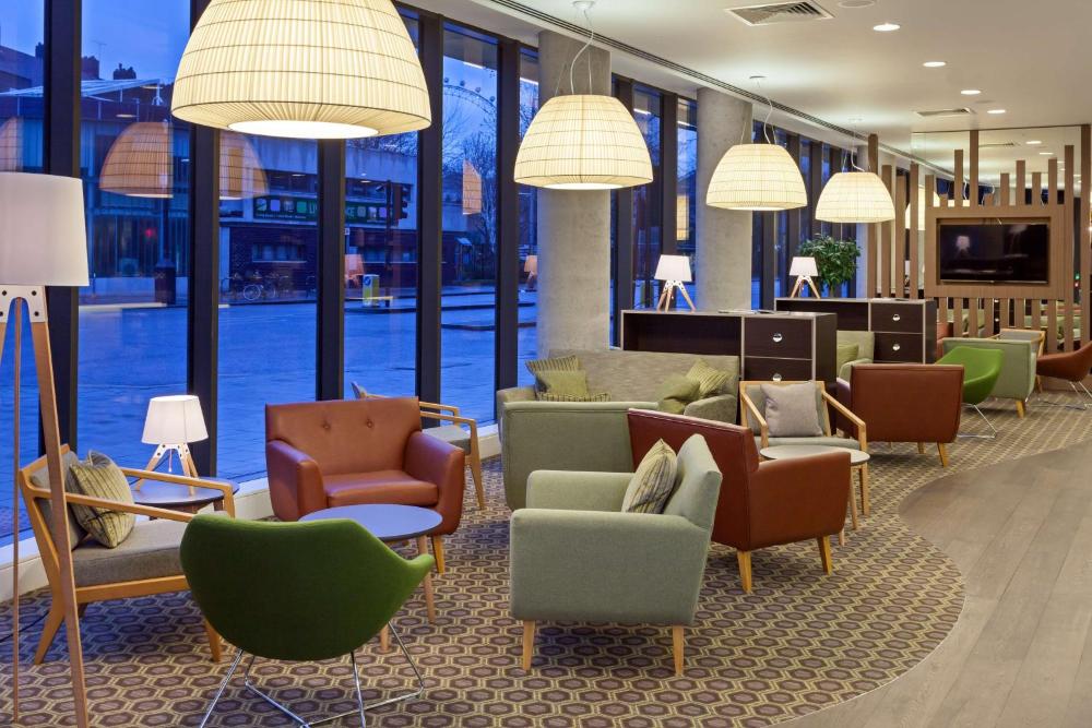 Lobby lounge with colorful armchairs and window seating at Hampton by Hilton London Waterloo