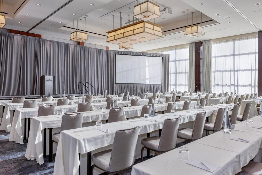 Conference room with white tables, chairs, and a projection screen at InterContinental Boston