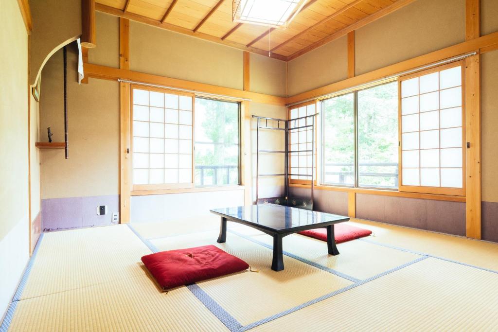 une pièce avec une table dans une pièce avec des fenêtres dans l'établissement 高野山 宿坊 増福院 -Koyasan Shukubo Zofukuin-, à Koyasan