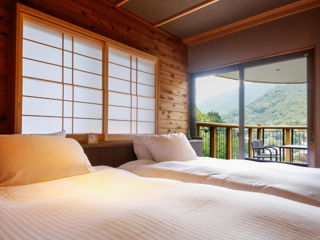 une chambre avec deux lits et une grande fenêtre dans l'établissement Asan Kotonami, à Manno 37 autres photos