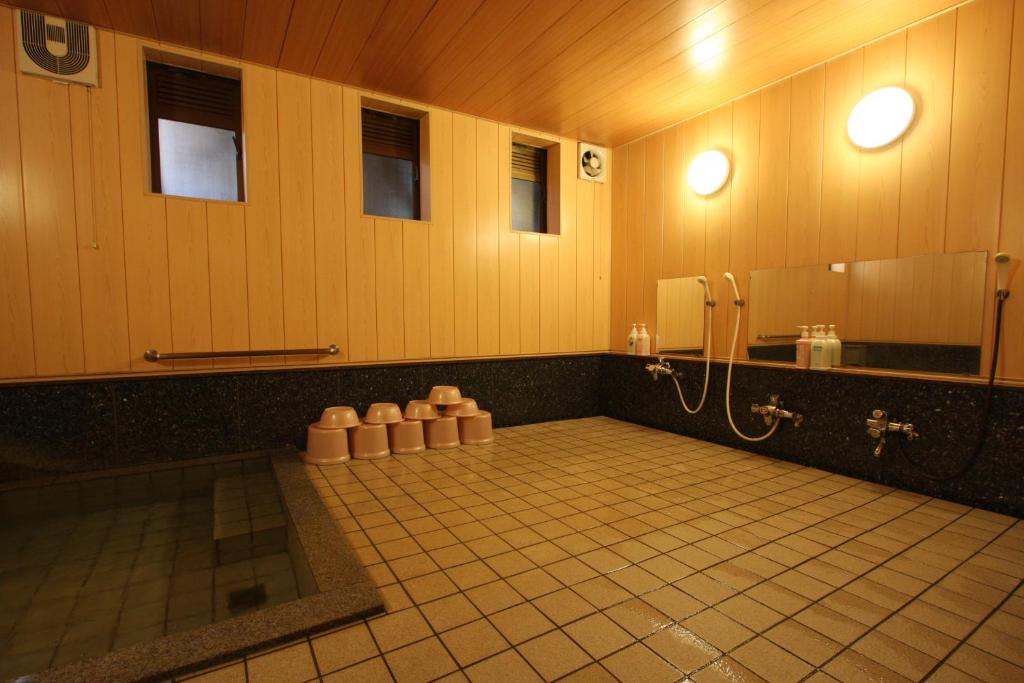 une salle de bain avec une douche, un lavabo et un miroir dans l'établissement Kawahiro, à Nozawa Onsen