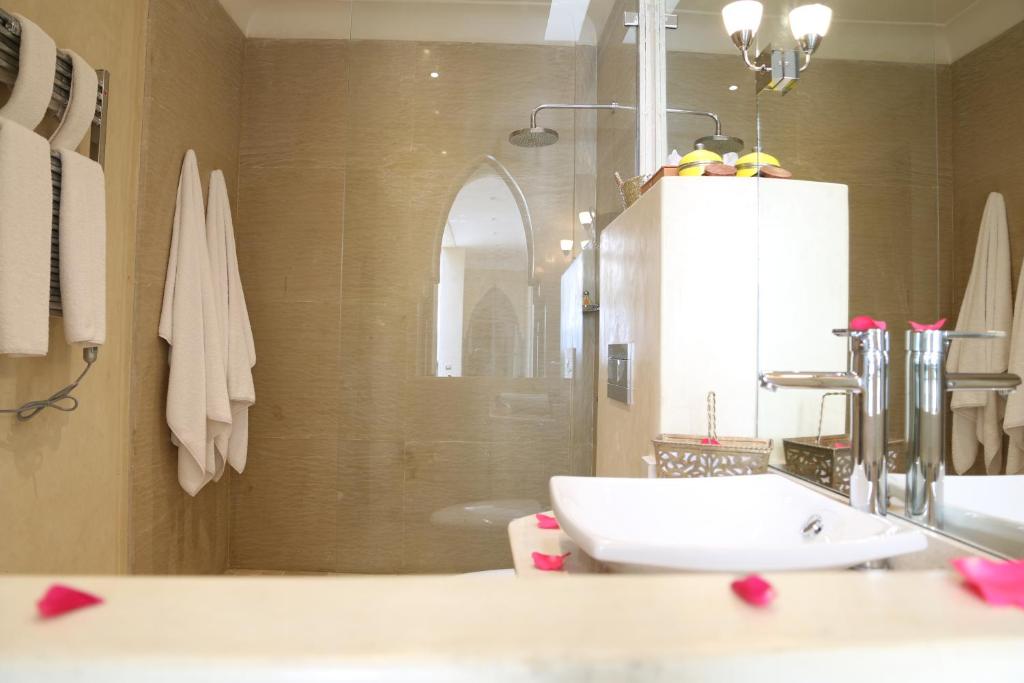 une salle de bain avec un lavabo blanc et une douche dans l'établissement Riad Infinity Sea, à Marrakech
