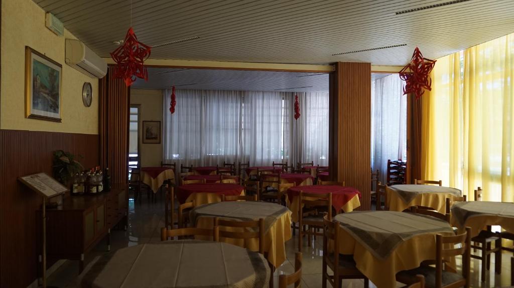 un restaurant avec des tables et des chaises dans une salle dans l'établissement Hotel Daria, à Rimini