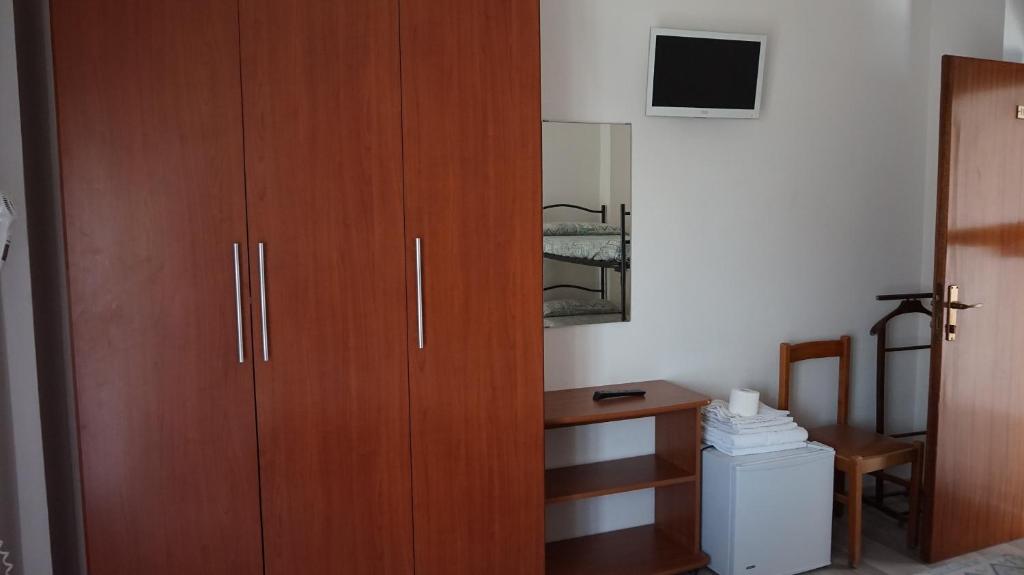 une grande armoire en bois dans une chambre avec un bureau dans l'établissement Hotel Daria, à Rimini